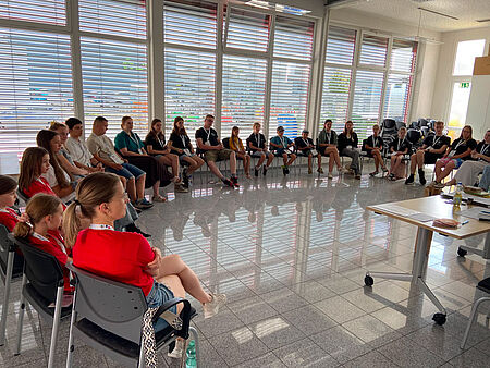 Kinder und Jugendliche sitzen im Kreis bei der JRK-Kinderversammlung.