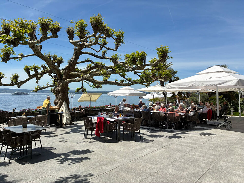 Seniorentagesausflug Bodensee Gemütliches Beisammensein auf einer Terrrasse eines Cafés am Bodensee.